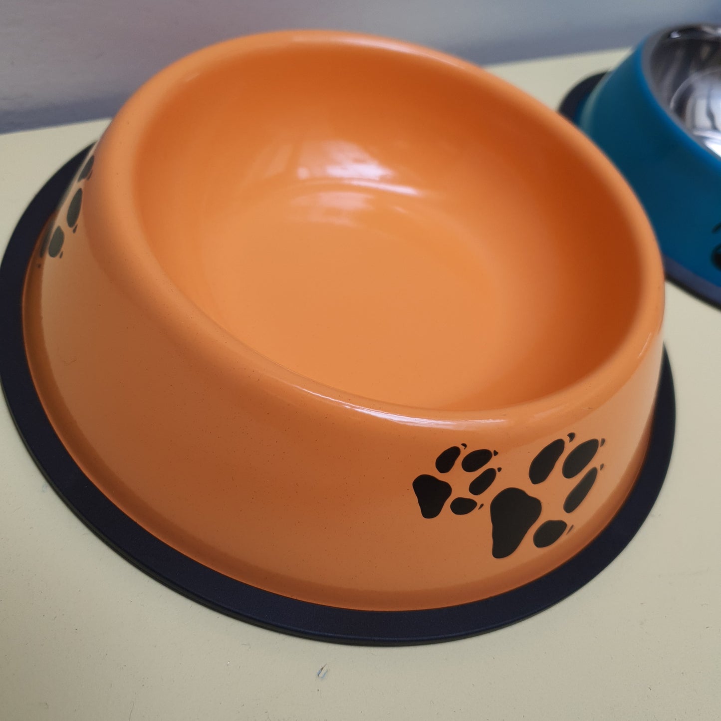 Plato comida de metal naranja con patitas.
